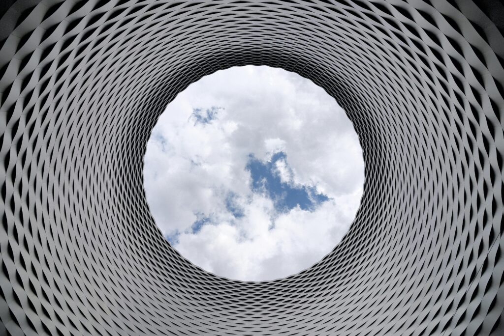 Low-angle Photography of Grey and Black Tunnel Overlooking White Cloudy and Blue Sky